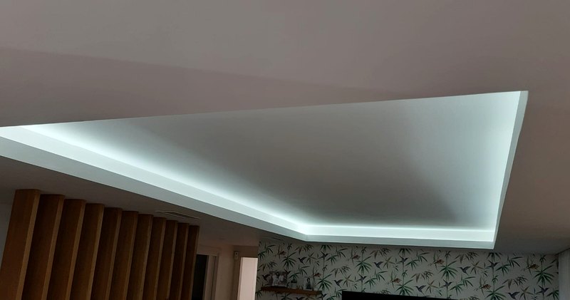 Falso techo con una moldura perimetral que esconde una tira de LED y proyecta la luz hacia arriba